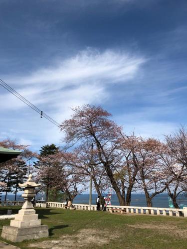 un parque con árboles y una valla y el agua en Guest House Asahi, en Otaru