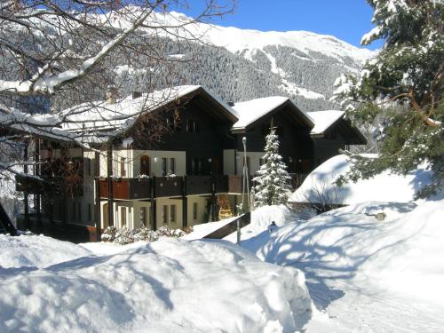 a house covered in snow in front of a mountain at Aragon V149 in Ernen