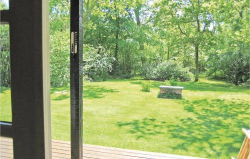 a view of a yard with a bench through a window at Holiday Home Sommerlystvej Gilleleje X in Gilleleje