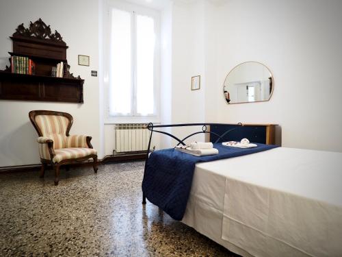 een slaapkamer met een bed met een spiegel en een stoel bij DIMORA SARZANO ACQUARIO - GENOVABNB it in Genua