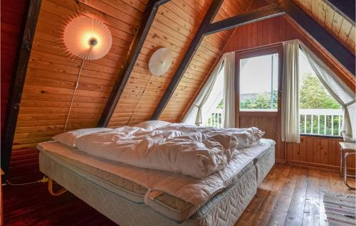 a bed in a wooden room with a large window at Holiday Home Ebeltoft - 05 in Ebeltoft