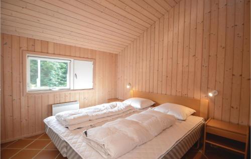 Bøtø ByにあるAwesome Home In Vggerlse With 4 Bedrooms, Sauna And Wifiの窓付きの木製の部屋の大型ベッド1台