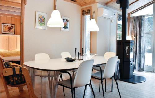 a dining room with a white table and chairs at Holiday Home Krondyrstien Væggerløse Denm in Marielyst