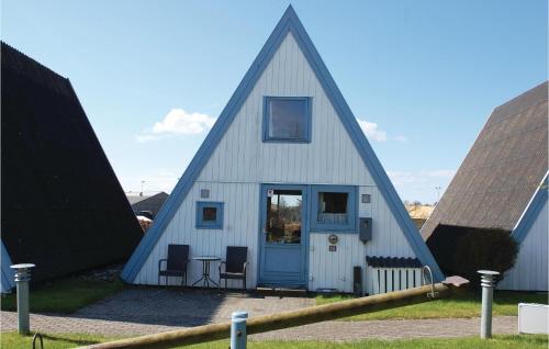 a triangular house with a blue door and two chairs at 3 Bedroom Lovely Home In Knebel in Knebel