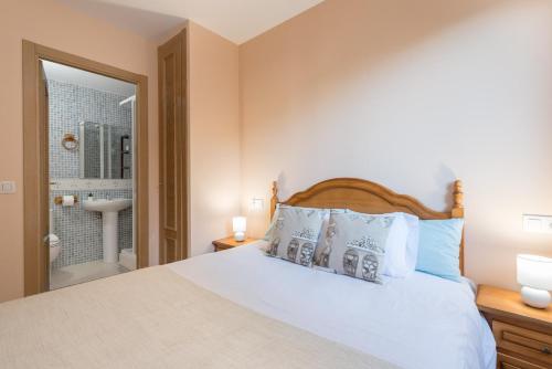 a bedroom with a large white bed with blue pillows at Apartamento Juclar in Soldeu