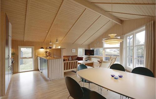 a kitchen and dining room with a table and chairs at Nice Home In Aakirkeby With 3 Bedrooms And Wifi in Vester Sømarken
