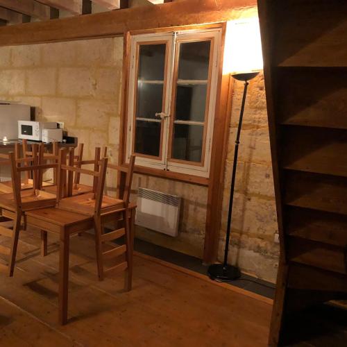 une salle à manger avec une table et des chaises et une fenêtre dans l'établissement Superbe Duplex Aux Arenes, à Arles