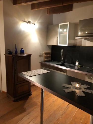 - une cuisine avec un plan de travail noir et un évier dans l'établissement Superbe Duplex Aux Arenes, à Arles
