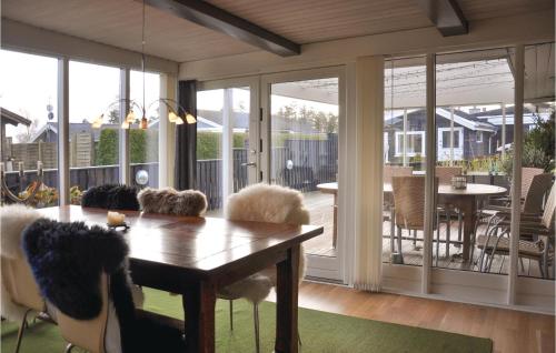 a living room with a table and sliding glass doors at Five-Bedroom Holiday Home In Otterup in Otterup