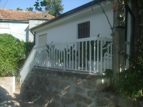 a white house with a white railing on a staircase at Casa Moinhos do Rio in Paredes