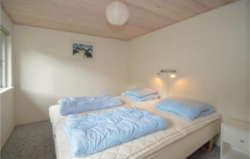 a bed with blue pillows on it in a room at 2 Bedroom Nice Home In Stege in Stege