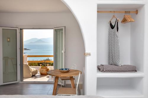 a room with a table and a view of the ocean at VILLA AGAPITOS in Naxos Chora