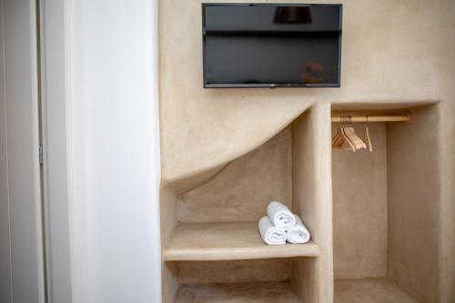 a room with a tv and a pair of white shoes at VILLA AGAPITOS in Naxos Chora