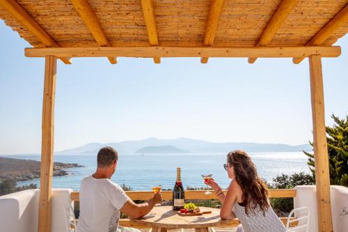 a man and a woman sitting at a table with wine glasses at VILLA AGAPITOS in Naxos Chora