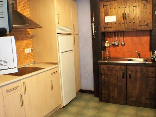 a kitchen with a white refrigerator and a sink at Casa Rural Arboliz in Ibarrangelu