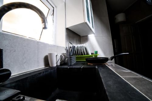 a kitchen counter with a sink and a window at Appart MRode Djidjole in Lomé