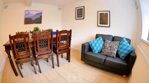a dining room with a table and a couch at Bike Park Lodge in Merthyr Tydfil
