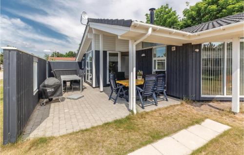a patio with a table and chairs and a grill at Three-Bedroom Holiday Home In Slagelse in Slagelse