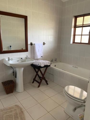 a bathroom with a sink and a tub and a toilet at Kransberg Country Lodge Guest Farm in Thabazimbi