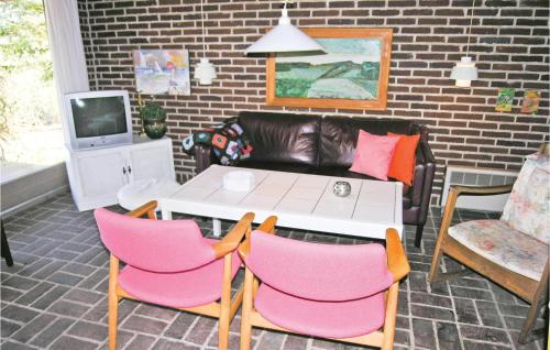 a living room with a white table and pink chairs at Holiday Home Harevænget in Asperup