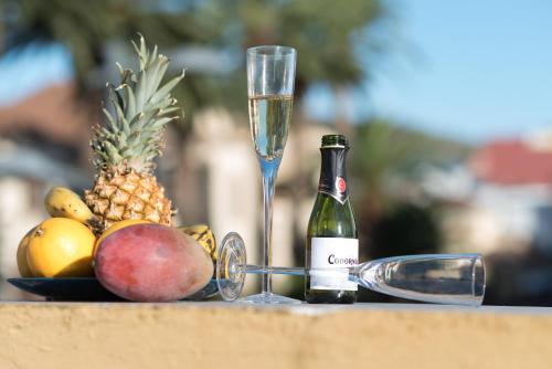 a bottle of champagne and a glass of fruit at CONCEPCIÓN SUITE PLAZA in Las Lagunas