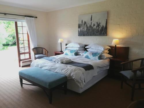 a bedroom with a large bed with blue pillows at Le Petit Vignoble in Cape Town