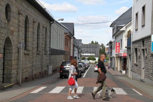 two women crossing a street with a dog on a crosswalk at Casa Maria in Saint-Vith