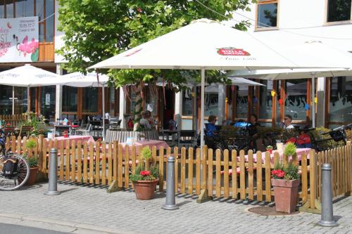 a wooden fence with potted plants and an umbrella at Casa Maria in Saint-Vith