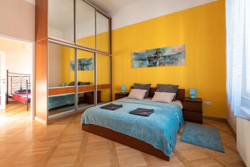 1 dormitorio con cama y pared amarilla en Patrik's Budapest Center Apartment, en Budapest