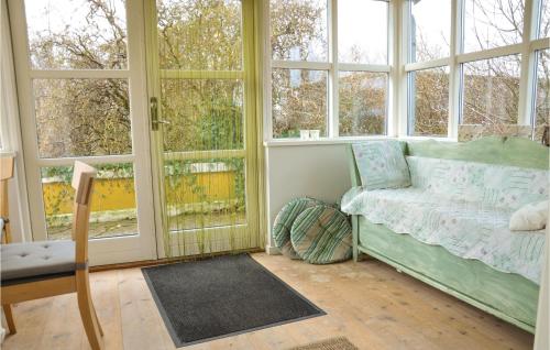 Habitación con ventanas, cama y silla en Awesome Home In Otterup With 2 Bedrooms And Wifi, en Otterup