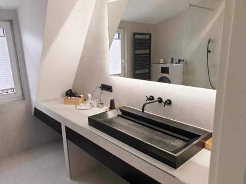 a bathroom with a sink and a mirror at Wunderschönes Penthouse im Herzen von Hameln in Hameln