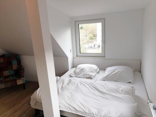 - un lit blanc dans une chambre avec fenêtre dans l'établissement Wunderschönes Penthouse im Herzen von Hameln, à Hameln