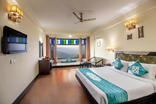 a bedroom with a large bed and a tv in it at Snow Valley Resorts Dalhousie in Dalhousie