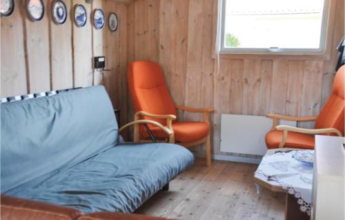 a room with two orange chairs and a bed at Gnilbo in Bogense
