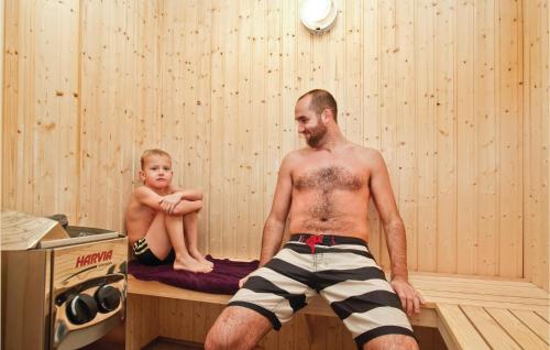 a man and a baby sitting in a sauna at 8 Bedroom Stunning Home In Nordborg in Nordborg