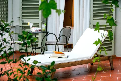 a bed on a patio with a table and chairs at Kenta Beach Hotel in Agios Ioannis Pelio