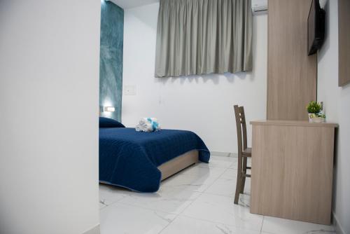 a bedroom with a bed with a blue blanket and a chair at Stabia Dream Rooms in Castellammare di Stabia