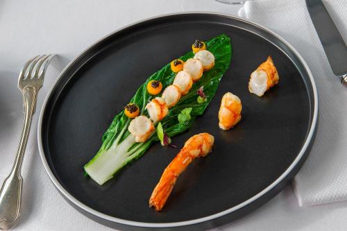 un plato de comida con camarones y verduras. en Hôtellerie Beau Rivage en Condrieu