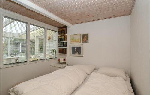 a bedroom with a bed with white sheets and a window at Amazing Home In Fan With Kitchen in Fanø