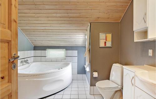a bathroom with a white tub and a toilet at Awesome Home In Oksbl With Wifi in Oksbøl