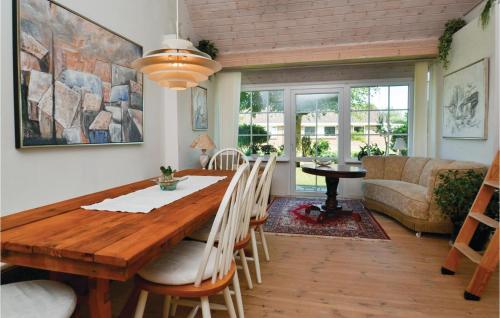 a dining room with a wooden table and chairs at Amazing Home In Fan With Kitchen in Fanø