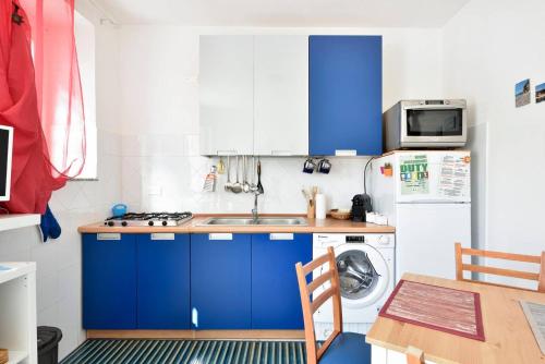 a kitchen with blue cabinets and a white refrigerator at Casa M&M in Cala Gonone