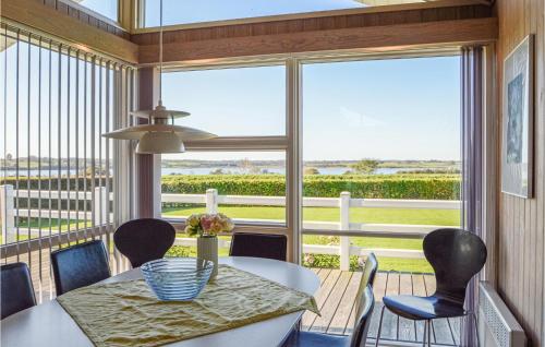 a dining room with a table and chairs and a large window at Holiday Home Søndervang Hejls in Hejls