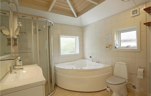 a bathroom with a tub and a toilet and a sink at Mølleparken in Gudhjem