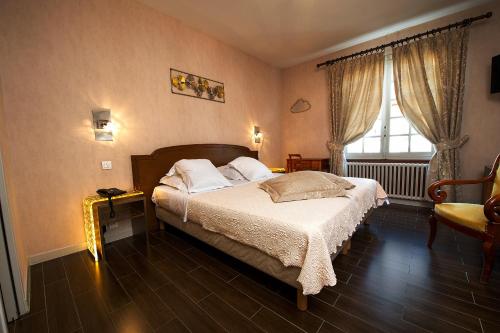 a bedroom with a bed and a window at Hôtellerie Beau Rivage in Condrieu