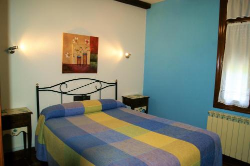 a bedroom with a bed in a blue room at Casa Rural Arboliz in Ibarrangelu