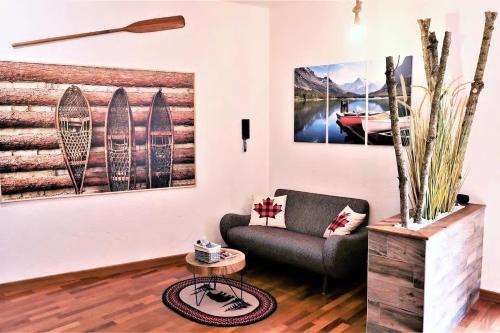 uma sala de estar com um sofá e pinturas na parede em Appart'Confort - Le Lodge em Saint-Brieuc