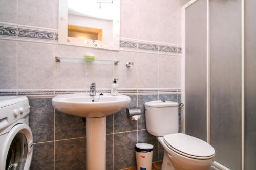 a bathroom with a toilet and a sink at VVROMPEOLAS in Puerto de Mogán