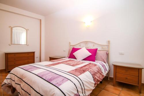 ein Schlafzimmer mit einem großen Bett mit rosa Kissen in der Unterkunft VVROMPEOLAS in Puerto de Mogán