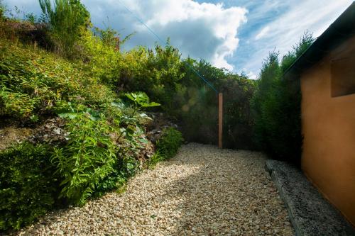 a garden with a gravel path next to a hill at GÎTE Le Moulineau in Deville